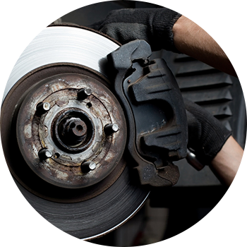 A person holding a brake disc in their hand.