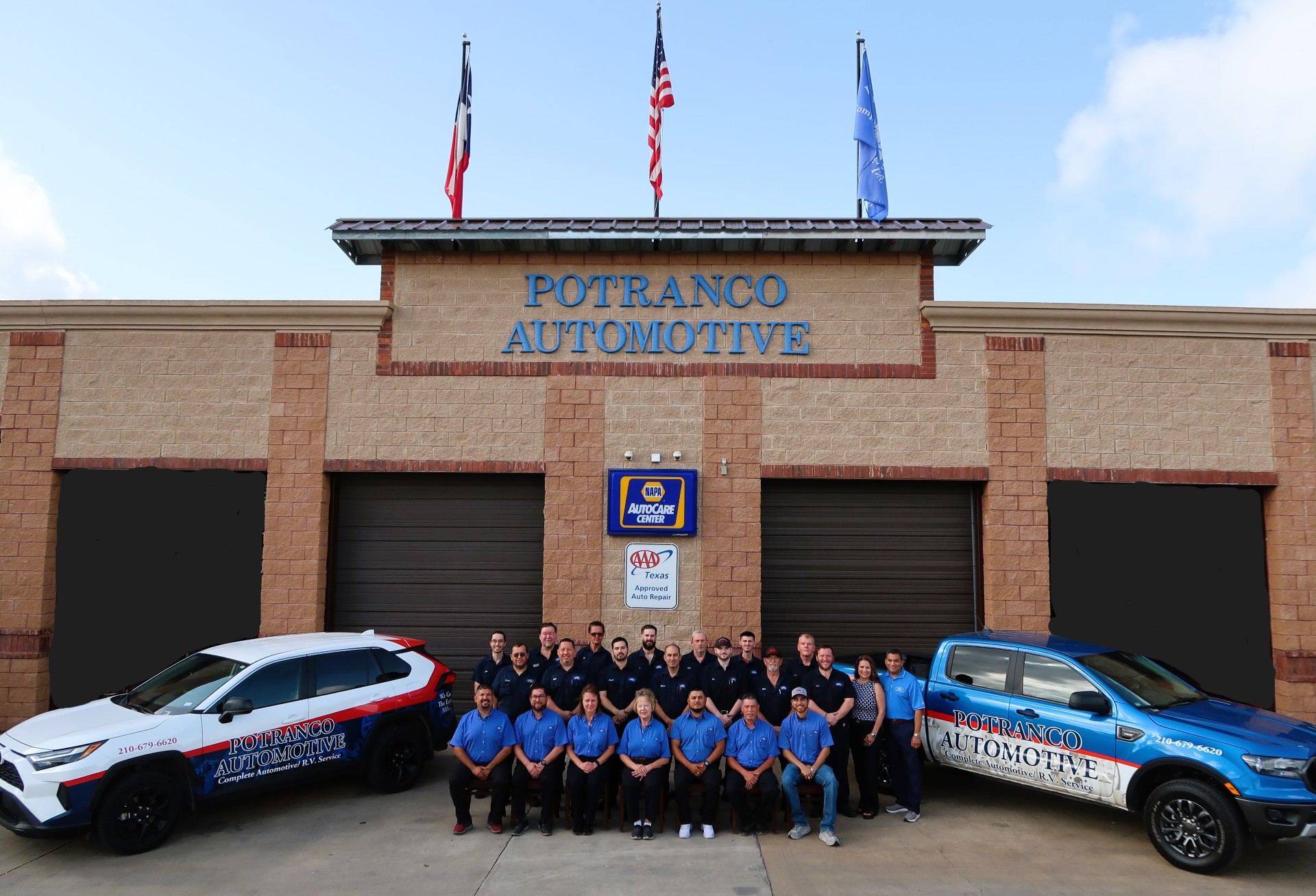 A group of people standing in front of two cars.